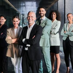 Multicultural business team headed by boss. Posing to camera cheerfully at the office.