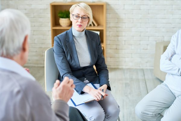 Woman consulting senior people in nursing home